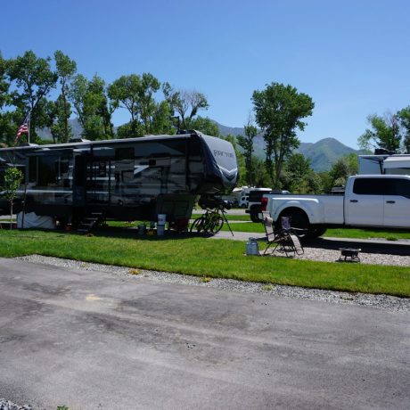 Upgraded premium RV sites with outdoor dining, seating, and propane fire grills for the ultimate camping experience at Riverside RV Luxury Resort in South Weber, Utah. 